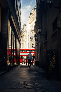 man walking in alley towards to red bus thumbnail