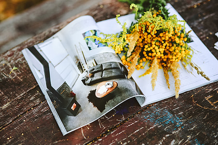 Yellow flowers with miscellaneous items on wooden floor thumbnail