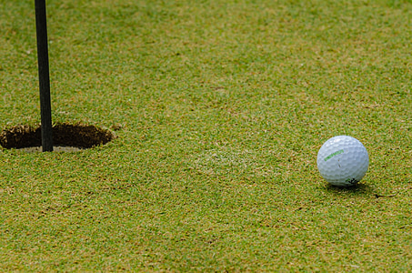 white golf ball near hole thumbnail