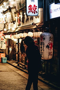 woman standing beside white and red paper lantern thumbnail