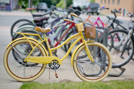 yellow cruiser bike parked beside bicycles thumbnail