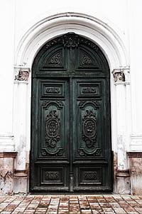 arch-shaped black wooden double doors during daytime thumbnail