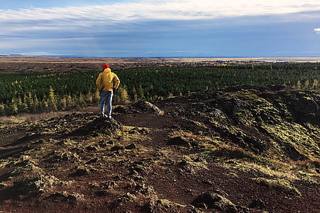person standing on rock cliff thumbnail