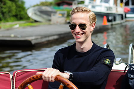 Smiling Man Driving Motorboat on Body of Water thumbnail