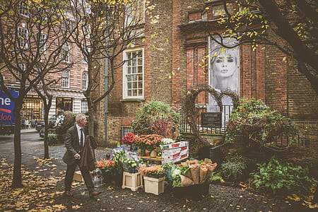 man walking near flower stand thumbnail