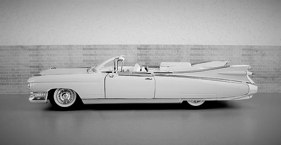 grayscale photography of classic convertible coupe near wall thumbnail