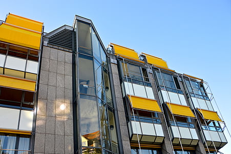 low angle of gray and yellow building undr blue sky thumbnail