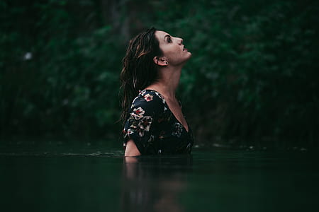 woman wearing black scoop-neck blouse near green plant looking above thumbnail