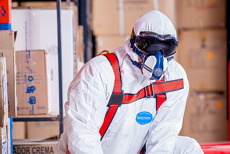 photo of man in white safety suit near cardboard boxes thumbnail