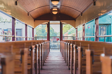 selective focus photography of building interior with brown wooden benches aligned symmetrically thumbnail