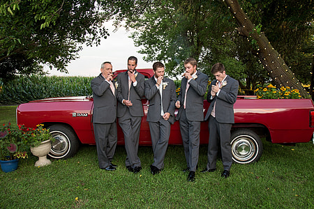group of men in wedding photo shoot with red car on background thumbnail