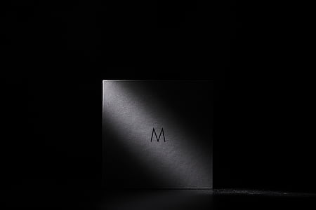 white M-printed box in dimmed room thumbnail